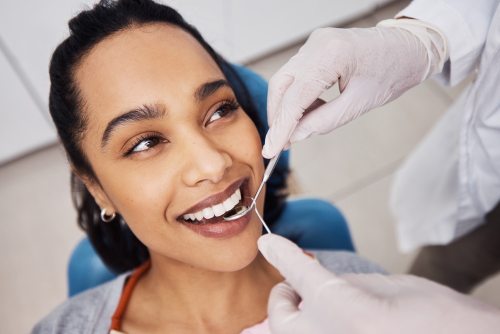 Smiling Dental Patient in Mitchellville, MD Hands, woman or dentist with tools for dental procedure, clean teeth or cavity removal in clinic. Mirror, excavator or patient with medical orthodontist for gum care, oral hygiene or smile for health